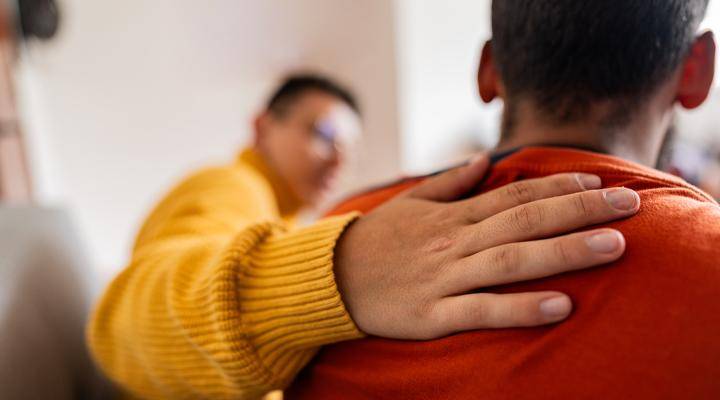 Close-up of supporting hand on a student's shoulder