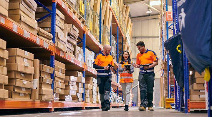 A supply chain and logistics team walk through a warehouse