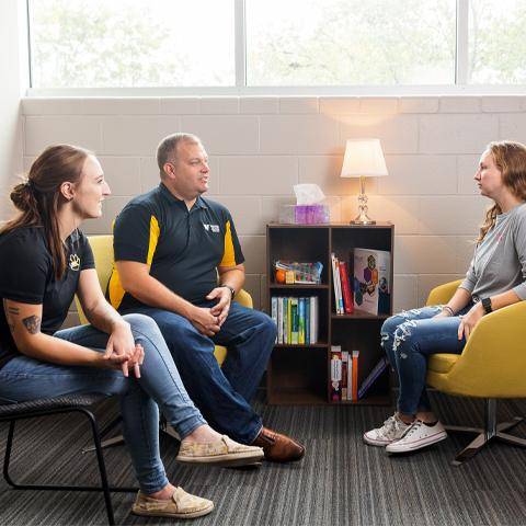 Professors in the Counseling Department work with a student in the Counselor Training Clinic.
