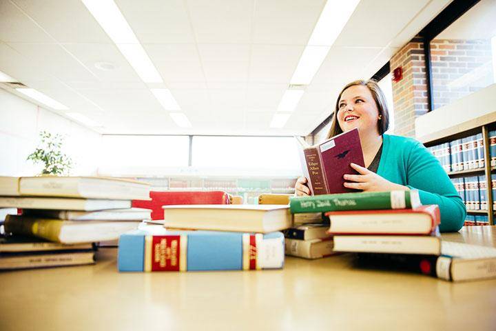 A student sits at a table with books