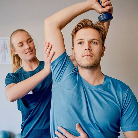 An athletic trainer works with a patient