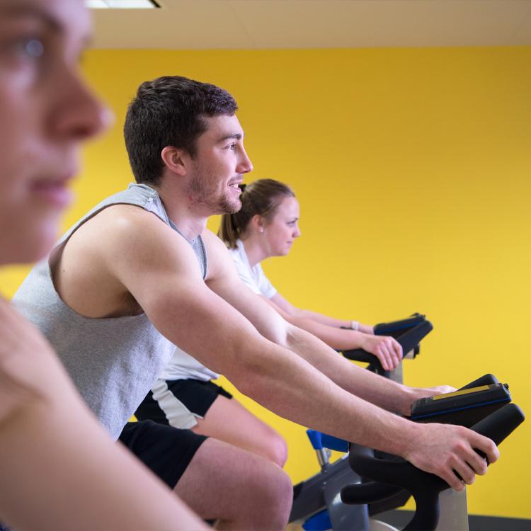 Students participate in a cycling class