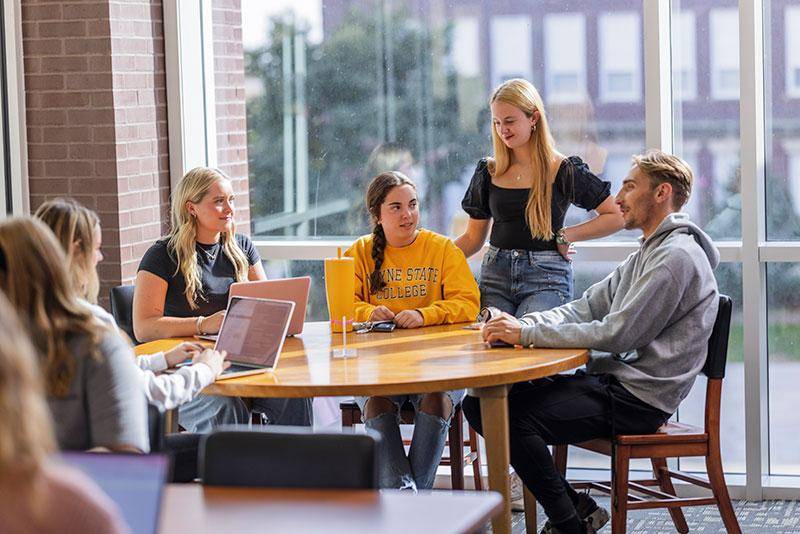 Photo of students sitting at a table in the library