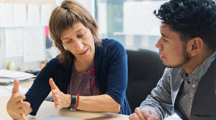 A higher education professional works with a student