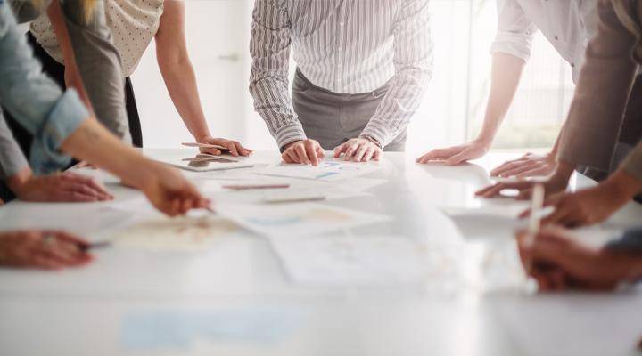 Business professionals gather around a table