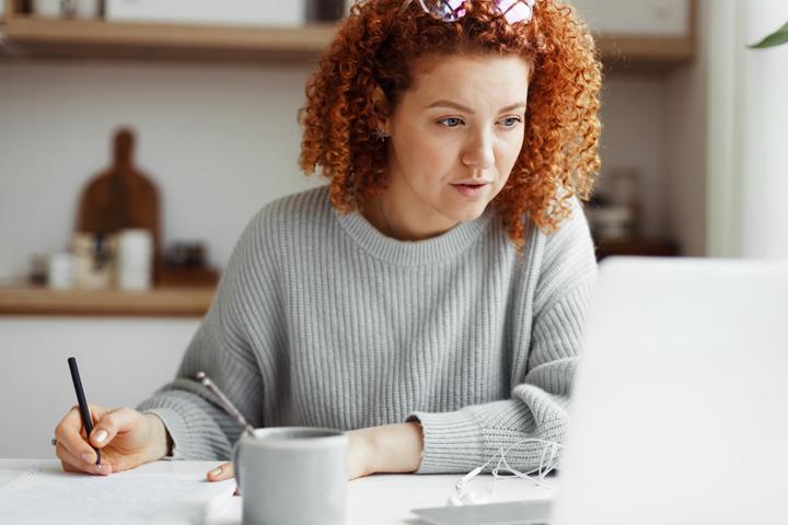 An adult woman takes a course on her laptop