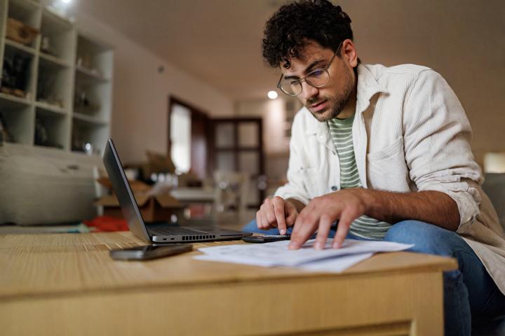 A man uses his laptop to review finances
