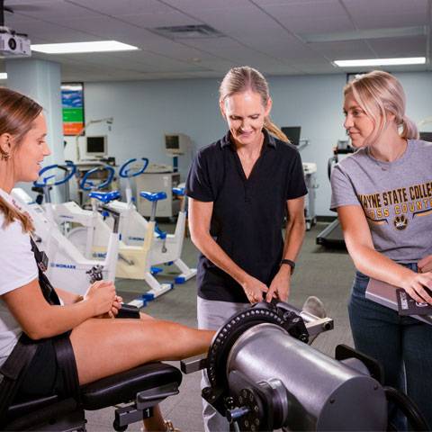 Dr. Kris Fox works with students in the Human Performance Lab