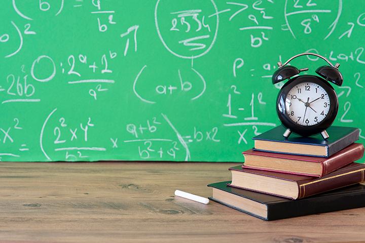 Books in front of a chalkboard with math equations