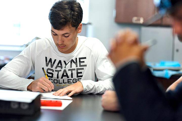 A student takes notes at a table