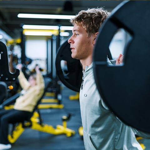 A student lifts weights in the Wellness Center