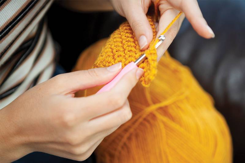 A young person crochets