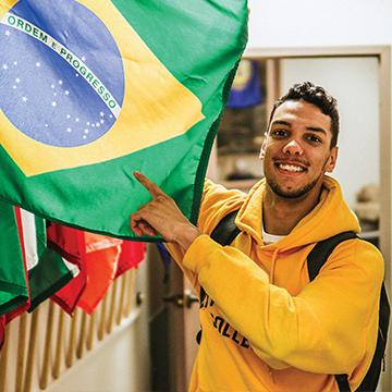 An international student points to a flag