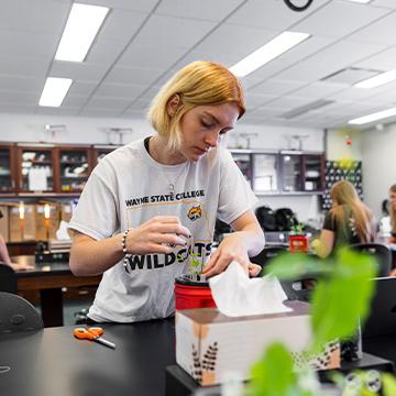 A students works with plans in a life sciences class