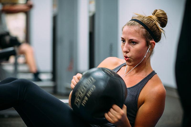 A girl works out with a medicine ball