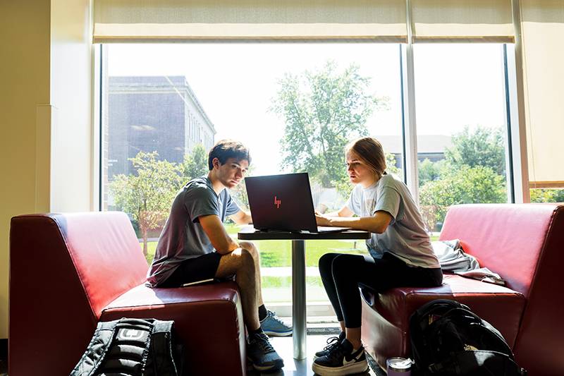 Two students working on a laptop computer