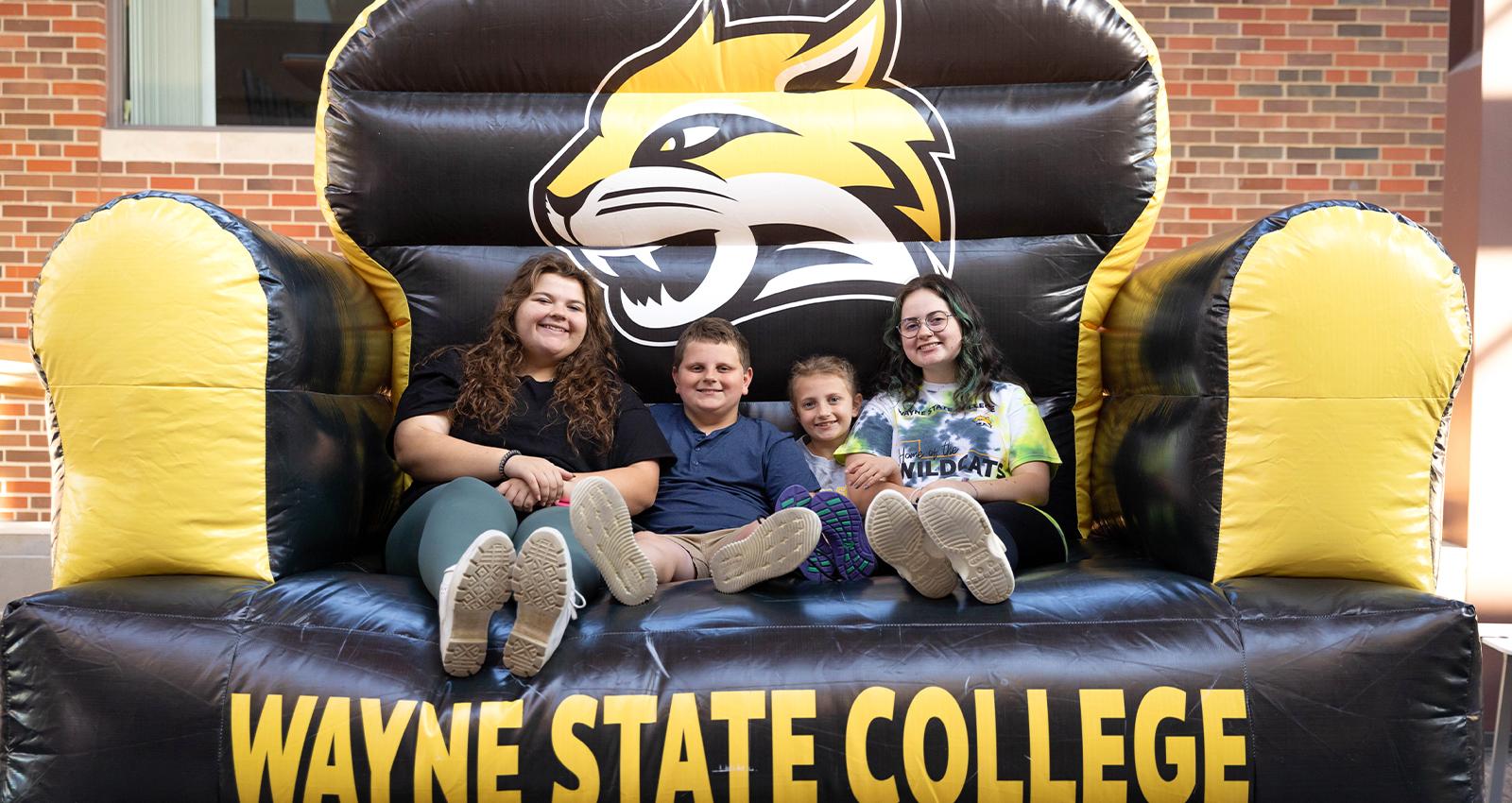 A WSC student and her younger siblings sit on a  giant inflatable chair