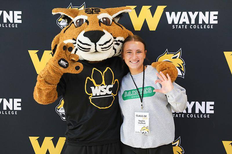A new student poses with Willy Wildcat