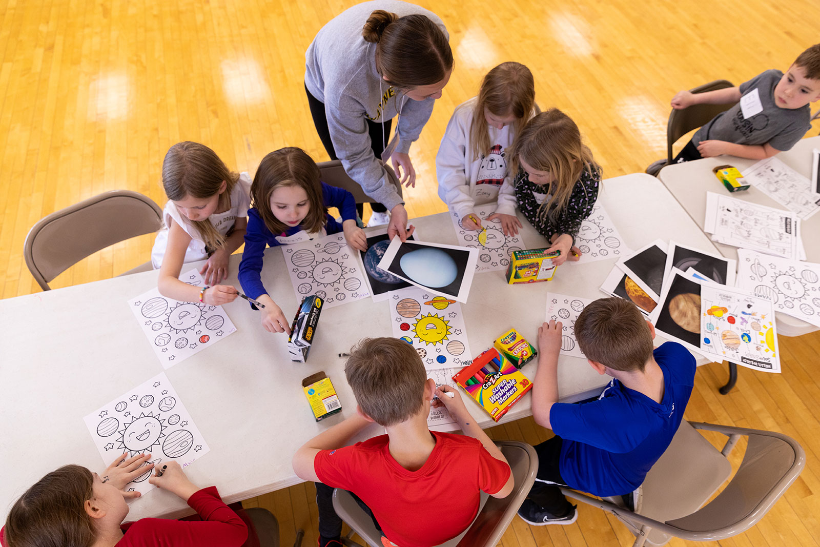 WSC students lead a group of elementary students in astronomy-themed coloring sheets