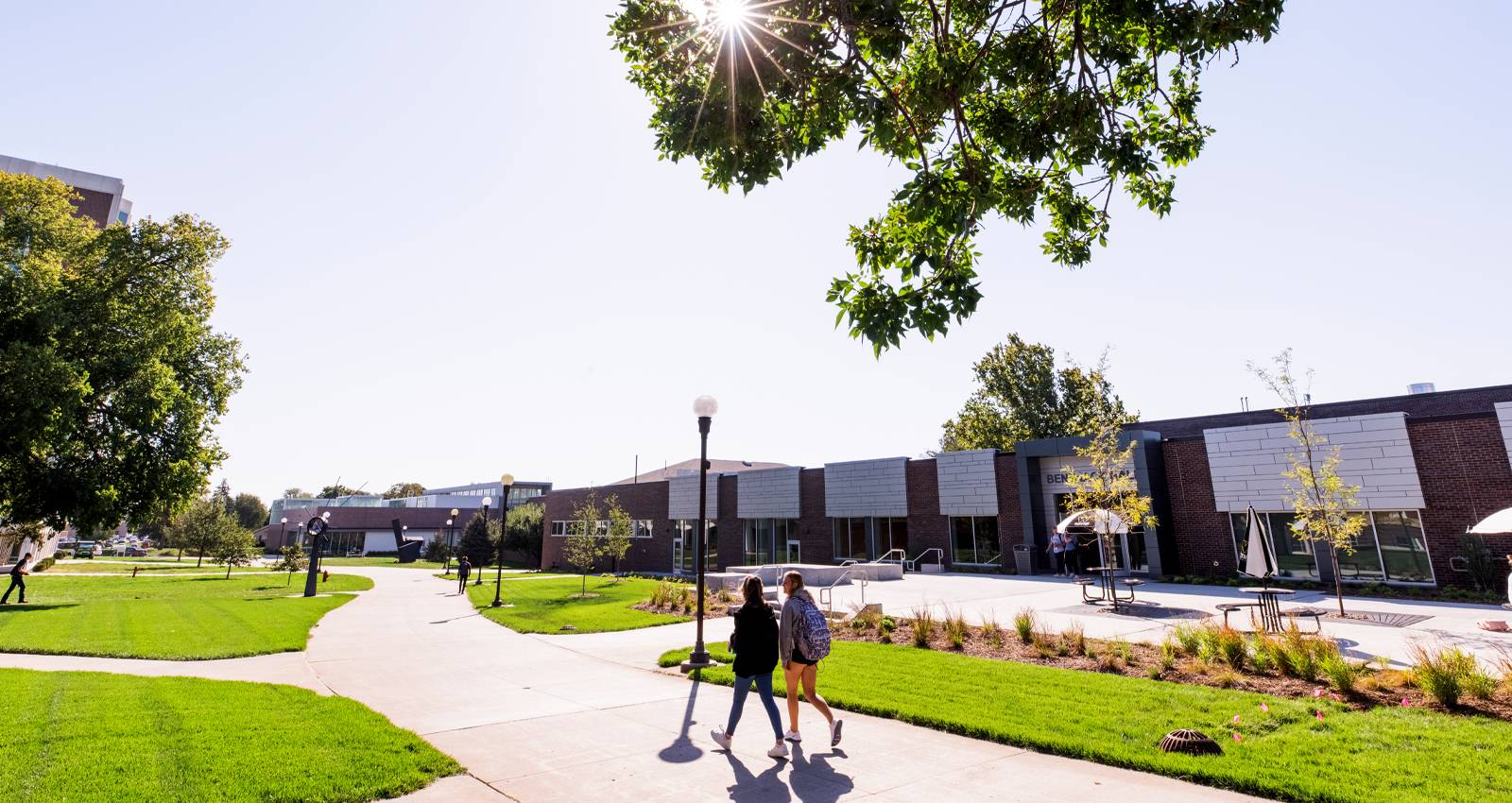 Students walk through campus near Benthack Hall