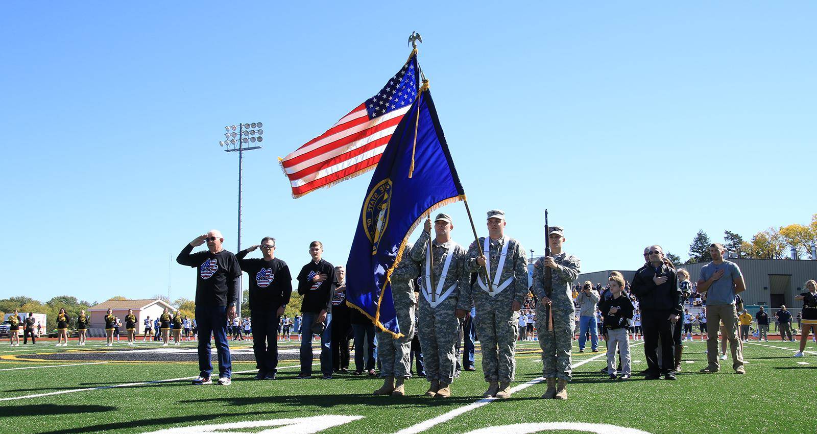 A group of military members present the colors on the Wayne State football field
