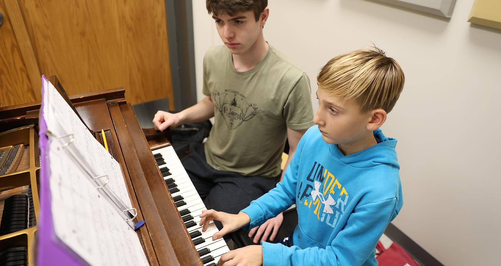 A young student takes piano lessons during Music Academy