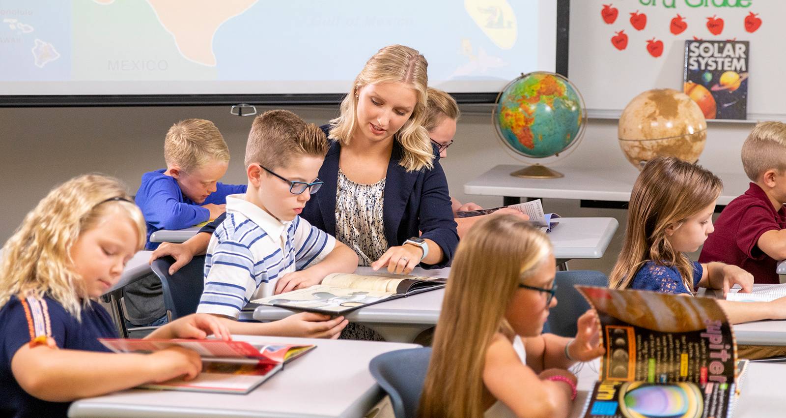 A WSC student helps children in an elementary classroom