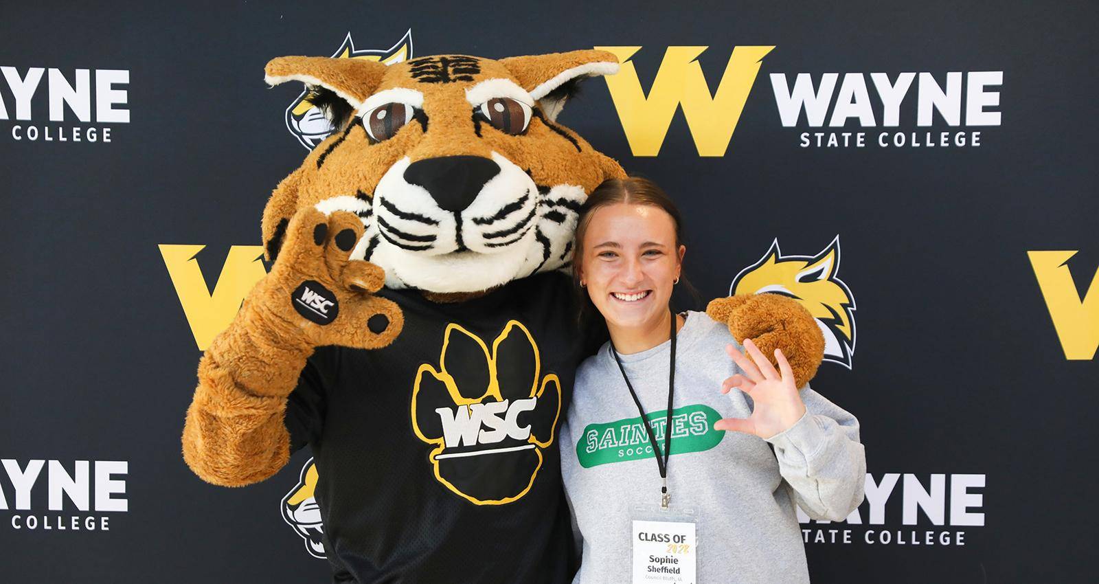 A new student poses with Willy Wildcat