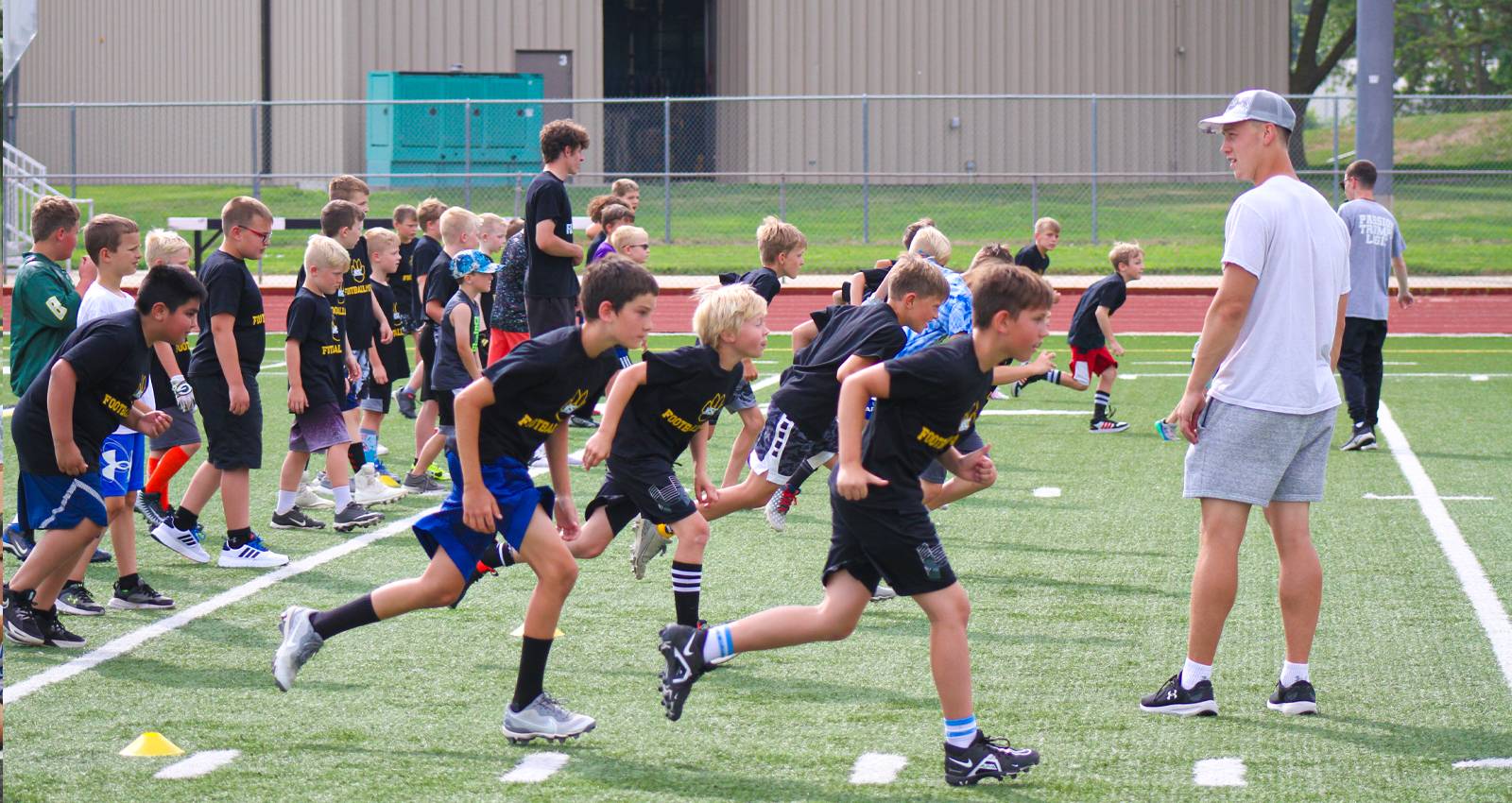 Area youth participate in a drill at the summer football camp