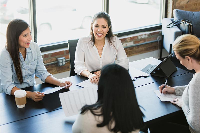 Women in a business meeting seated around a table