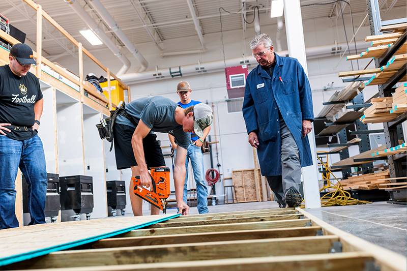 Construction management degree students work with a professor in the construction lab at WSC