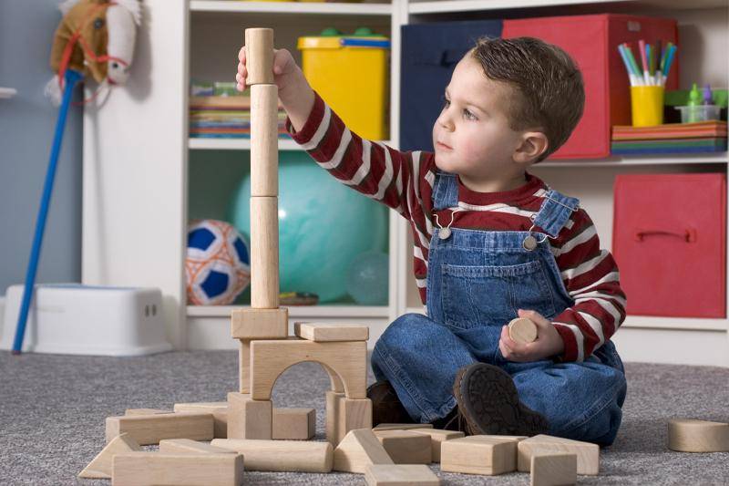 Early Childhood degree concept featuring a young child playing with blocks