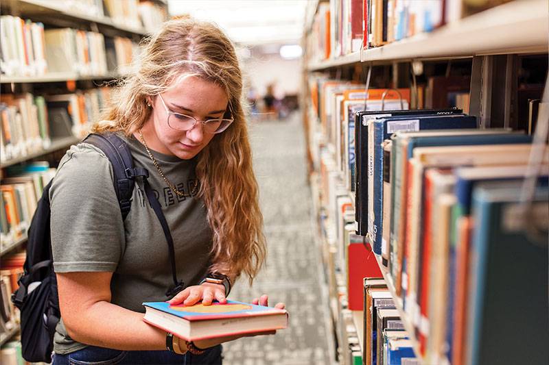 English literature and writing degree concept featuring a student in the library at WSC