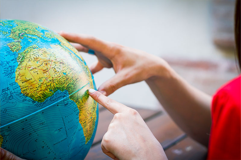 Geography degree concept featuring a student with a globe