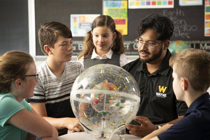 A Geography Education degree student teaches children in a classroom
