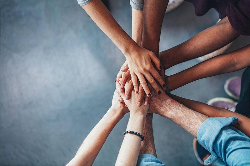 A team of people join hands