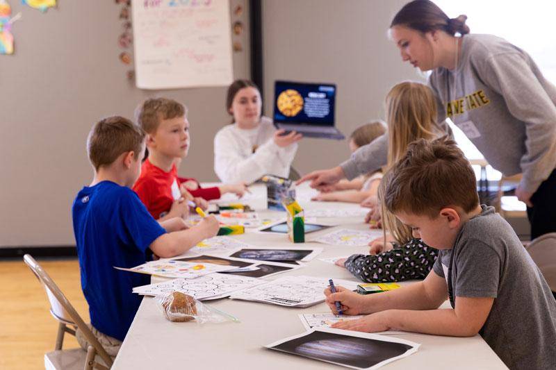 Two WSC students work with young children
