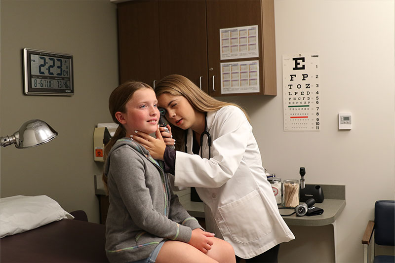 Pre-physician assistant degree concept featuring a WSC student performing a patient exam