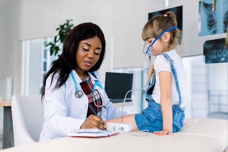 A respiratory therapist works with a child