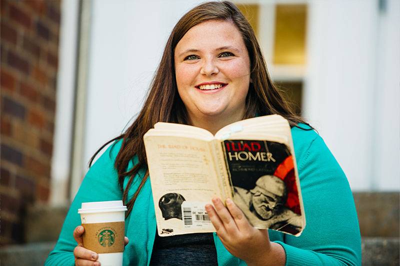 Secondary English education degree concept featuring a WSC student reading at the library