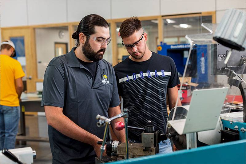 A student in the STS education program works with a professor in a manufacturing lab at WSC