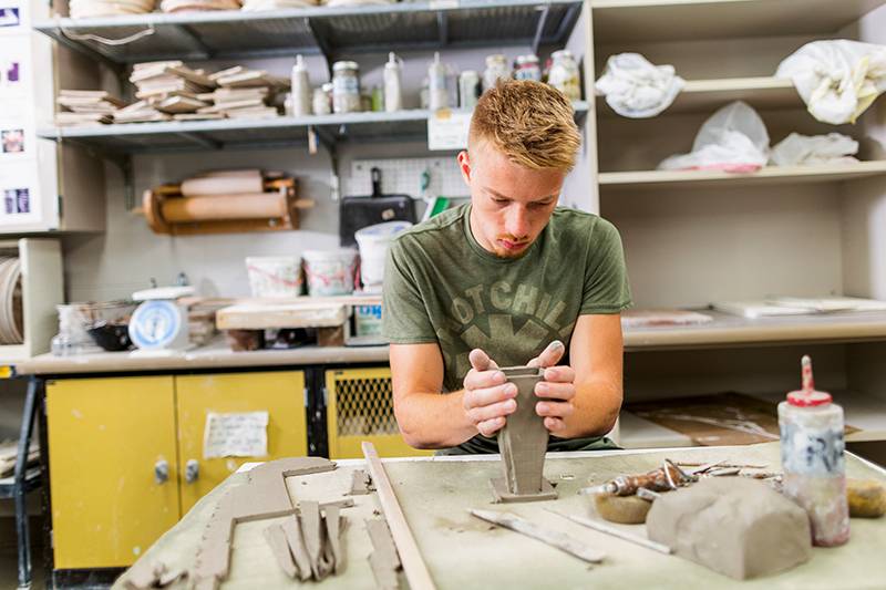 A studio art degree student works in the pottery lab at WSC