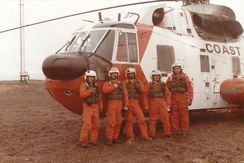 Curt Ott and a group of people by a helicopter