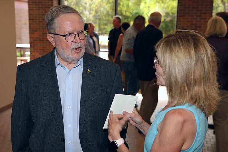 Loren Kucera visits with a guest at his retirement party.