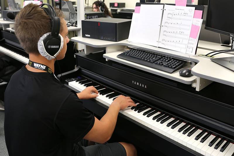 A student plays piano at Summer Music Camp
