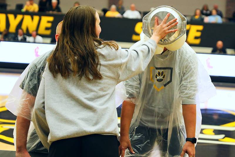 Assistant baseball coach Tyler Vaughn gets pied in the face in Rice Auditorium