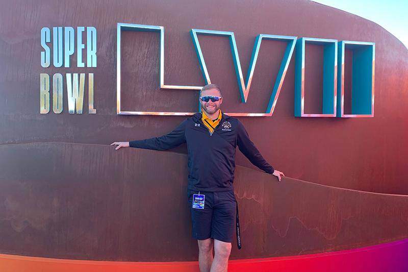 Photo of Preson Davis in front of the Super Bowl LVII sign