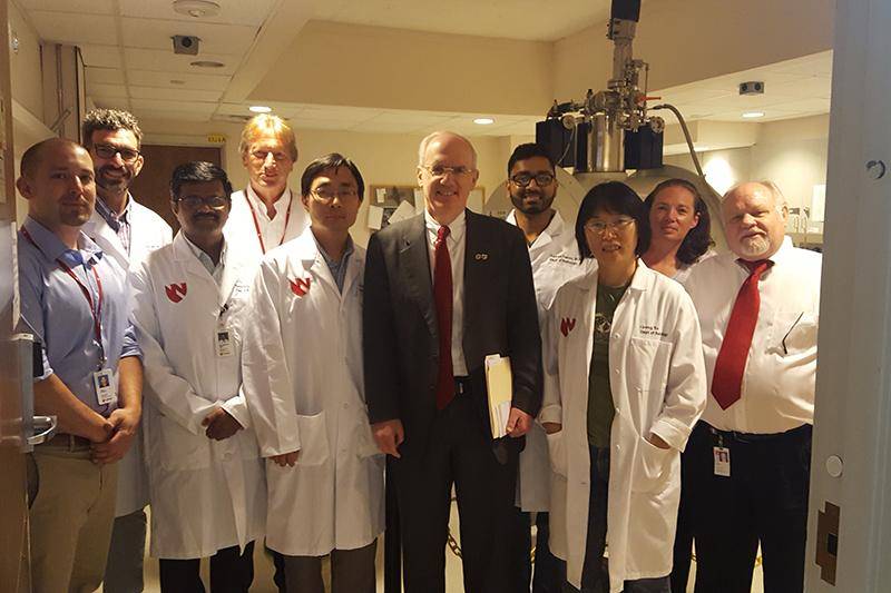 Shea Lundeby (far left) with UNO/UNMC Chancellor Jeffrey Gold (center) and the research department