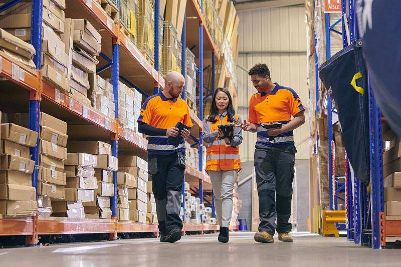 A supply chain and logistics team walk through a warehouse