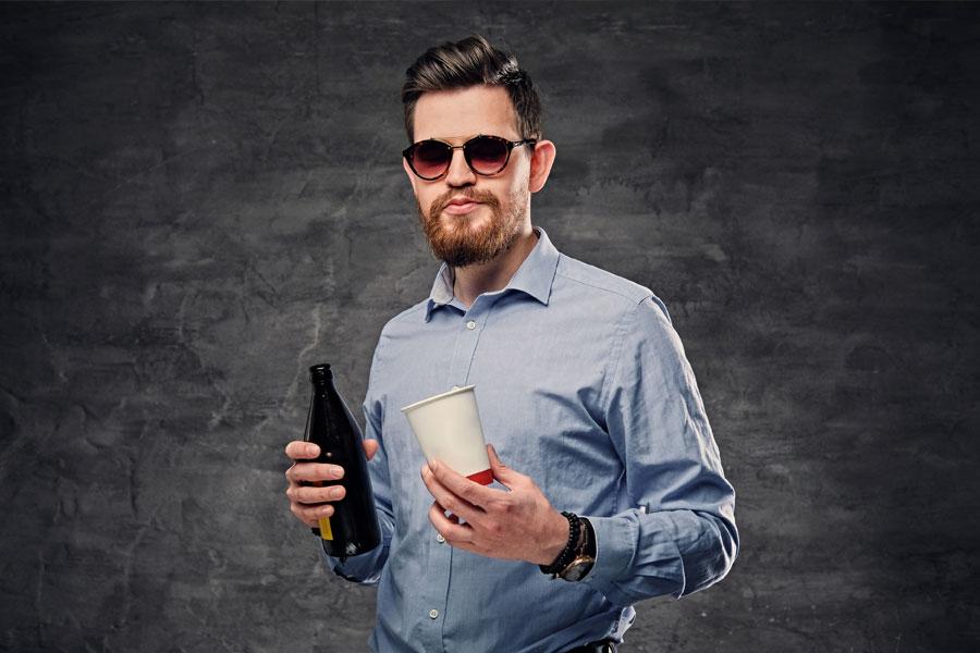 A man holds beer and coffee